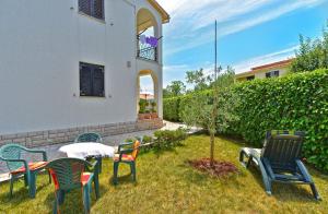 un groupe de chaises et une table dans une cour dans l'établissement Ferienwohnung für 4 Personen ca 35 qm in Fažana, Istrien Istrische Riviera, à Valbandon