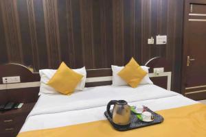 a hotel room with a bed with yellow pillows at HOTEL R K PALACE in Bhopal