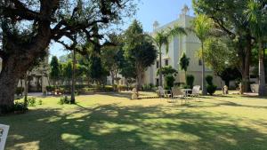 een gebouw met tafels en stoelen in een park bij Roop Vilas Palace in Nawalgarh