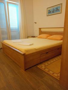 a bedroom with a large wooden bed in a room at Apartment Toni in Duće
