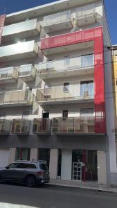 une voiture garée devant un immeuble avec balcon dans l'établissement Central Modern Studio Bari, à Bari