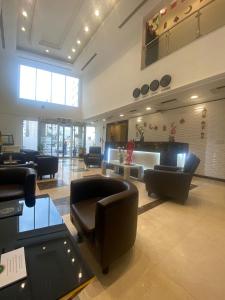 un vestíbulo con sofás y sillas en un edificio en A Line Hotel en Doha