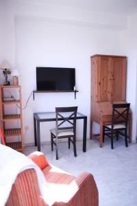 a living room with a tv and a table and chairs at SE - Peaceful Shiny Apartment Near Fibes in Seville