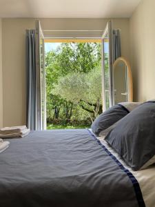 sypialnia z łóżkiem i dużym oknem w obiekcie Les marguerites w mieście Vers Pont du Gard