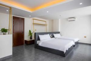 een slaapkamer met een groot bed met witte lakens bij CloverHome in Dong Hoi