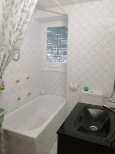 Baño blanco con bañera y lavamanos en Verano, en Alicante
