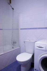 a white bathroom with a toilet and a shower at SE - Peaceful Shiny Apartment Near Fibes in Seville