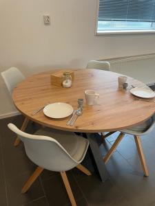 een houten tafel met twee stoelen en een tafel met borden en kopjes bij Stadsappartement Valkhof in Nijmegen