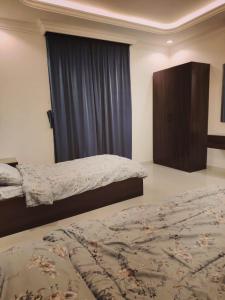 1 Schlafzimmer mit 2 Betten und einem großen Fenster in der Unterkunft عمارة المهدية in Riad