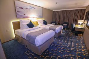 En eller flere senge i et værelse på Cheerful Al Waha Hotel Unayzah - فندق شيرفل عنيزة