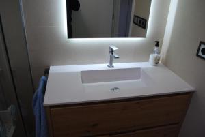 a bathroom with a white sink and a mirror at Casa los Canarios in Irijoa