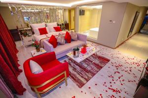 a living room with a couch and a red chair at Cheerful Al Waha Hotel Unayzah - فندق شيرفل عنيزة in Unayzah