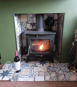 a stove in a room with a tile floor at Guildford Road Cottage in Ash