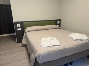 um quarto com uma cama com duas toalhas em Da Noi Trattoria Hotel em Vergato