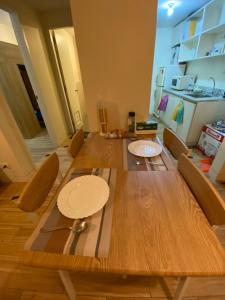 Jalang的住宿－Holland Park Condominium，餐桌、椅子和木桌