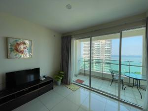 a living room with a television and a balcony at Penang Mansion One Suites By AuroraHomes in George Town