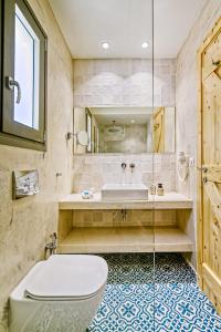 a bathroom with a tub and a toilet and a sink at Kumquart estate- Bergamot in Aspiotádes