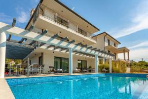 eine Villa mit Swimmingpool und ein Haus in der Unterkunft Ferienhaus mit Privatpool für 8 Personen ca 234 m in Malinska, Kvarner Bucht Krk in Malinska