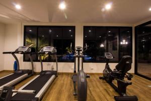 a gym with two treadmills and two exercise bikes at Phu Dahla Apartments in Ban Khlong Haeng