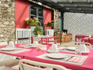 una mesa rosa y sillas en un patio en Agriturismo Rossolampone, en San Bernardino Verbano