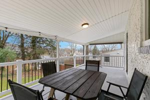 a porch with a wooden table and chairs at 4-bedroom-Private cozy backyard w firepit in Ephrata