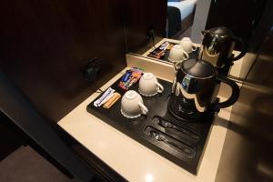 una mesa con tetera y tazas de té. en St George's Hotel - Wembley, en Londres