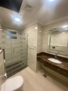 y baño con ducha, aseo y lavamanos. en A Line Hotel en Doha