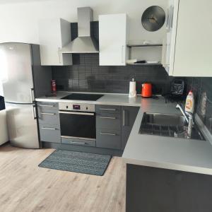 una cocina con electrodomésticos de acero inoxidable y armarios blancos en Apartmán Ptice, en Ptice