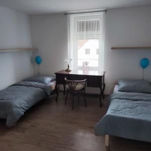 een slaapkamer met 2 bedden, een bureau en een tafel bij Apartmán Ptice in Ptice