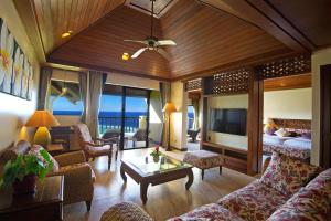 uma sala de estar com um sofá e uma cama em Aqua Resort Club Saipan em Saipan