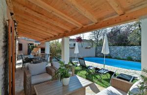 eine Terrasse mit einem Tisch, Stühlen und einem Pool in der Unterkunft Ferienhaus mit Privatpool für 10 Personen in Batlug, Istrien in Žminj