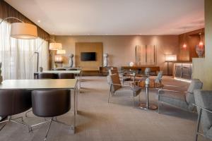 a living room with tables and chairs in a hotel room at AC Hotel Vicenza by Marriott in Vicenza