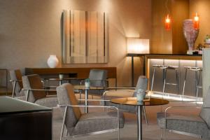 una sala d'attesa con tavoli e sedie di AC Hotel Vicenza by Marriott a Vicenza