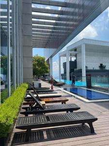 a row of benches sitting next to a swimming pool at Vinson Suites at Platinum KLCC in Kuala Lumpur