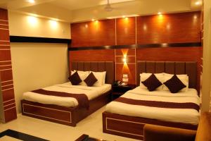 a hotel room with two beds in a room at Hiltown Hotel in Sylhet