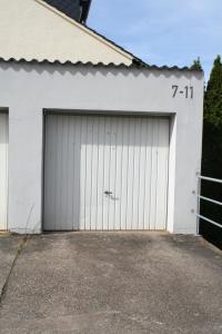 un garaje con dos puertas en un edificio blanco en Ferienwohnung Montabaur, en Montabaur