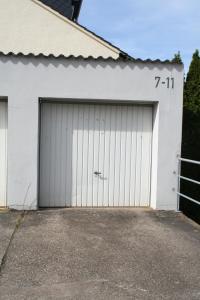 a garage with two doors on a white building at Ferienwohnung Montabaur in Montabaur