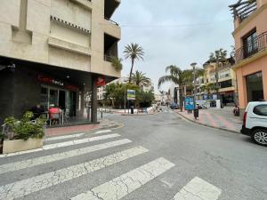 an empty city street with a white car parked next to a building at Casa amplia ideal en pleno centro del casco histórico de Almuñecar in Almuñécar