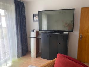 a flat screen tv sitting on top of a black cabinet at Ferienwohnung Lug in´s Land in Fichtelberg