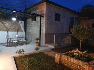 ein kleines Haus mit einer Terrasse und einem Tisch in der Unterkunft Center Lake House in Shkodra