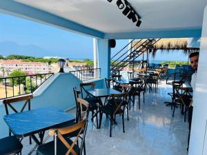 una fila de mesas y sillas en el balcón de un restaurante en Blue Golden Sea Hotel, en Kusadasi