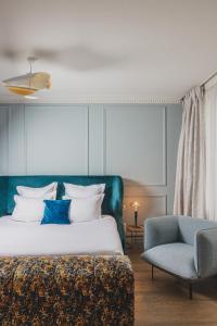 a bedroom with a bed and a blue chair at Hôtel Singulier Bordeaux - Boutique Hôtel & Spa Anne Semonin in Bordeaux +37 photos