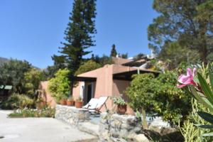 a house with a pink flower in front of it at Anemos - Holiday Beach Houses in Keratokampos