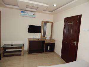 a room with a bed and a tv and a mirror at HOTEL BREEZE NEW JALPAIGURI in Siliguri