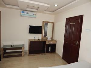 a room with a bed and a tv and a mirror at HOTEL BREEZE NEW JALPAIGURI in Siliguri