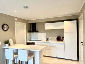 a kitchen with white cabinets and a table and chairs at Havn i Etne with fjordview in Etnesjøen