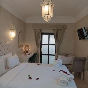 Un dormitorio con una gran cama blanca con flores. en Riad Palais Blanc & Spa, en Marrakech