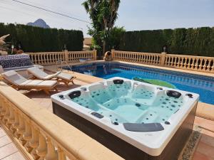 a hot tub on a balcony next to a swimming pool at Luxury Villa - pool, hot tub, aircon, TVs, home cinema, office, Gbit Internet, sports equipment, car in Calpe