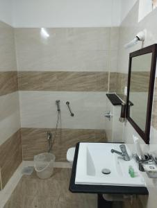 a bathroom with a sink and a mirror and a toilet at ANNAI RESIDENCY in Vellore