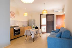 Una sala de estar con un sofá azul y una mesa. en Casa vacanze near airport, en Cinisi